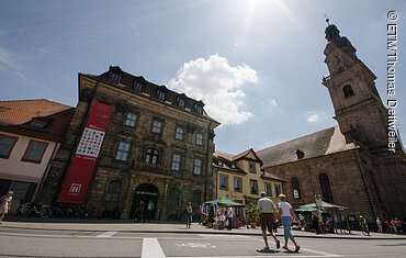 Ein historisches Museums-Gebäude, daneben eine Kirche.