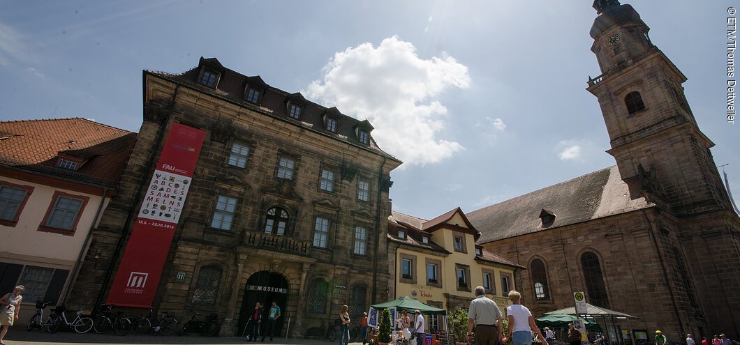 Ein historisches Museums-Gebäude, daneben eine Kirche.