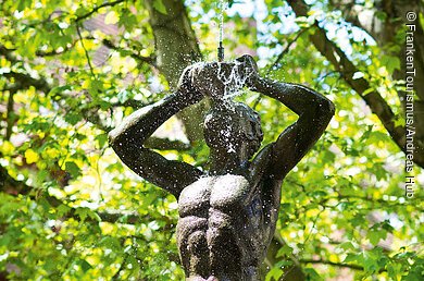 Tritonbrunnen (Nürnberg, Städteregion Nürnberg) Ein Brunnen, der eine wasserspuckende Statue zeigt