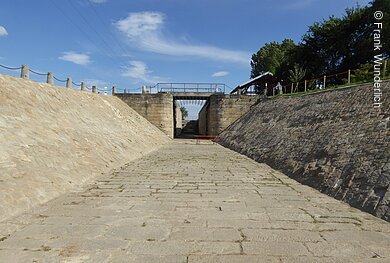 Schleuse 94 (bei Eggolsheim, Fränkische Schweiz) Ein Flussbett aus Steinen gebaut, am Ende eine Brücke mit Schleusentoren