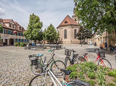 Ein frühlingshafter Stadtplatz mit Sandsteingebäuden, unter anderem eine Kirche