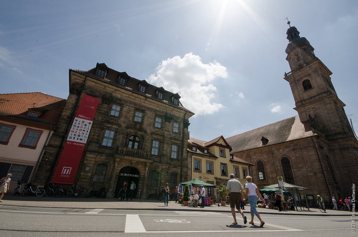 Ein historisches Museums-Gebäude, daneben eine Kirche.