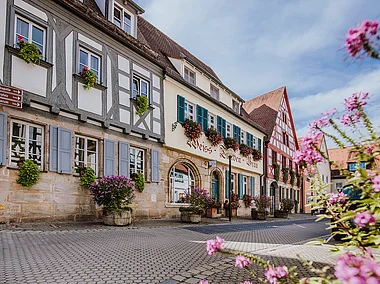 Forchheimer Fachwerk (Forchheim, Fränkische Schweiz) Ein Reihe an Fachwerkhäusern, davor bunt blühende Blumen
