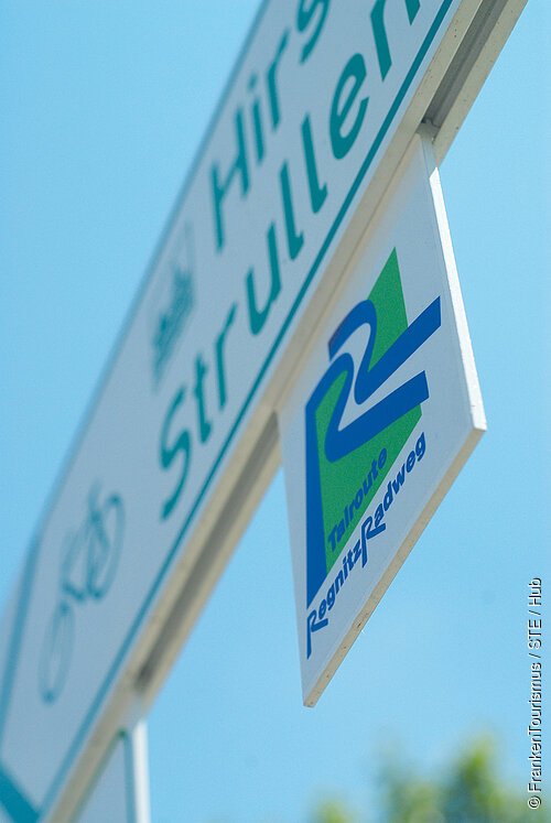 Verkehrsschild mit Fahrradpiktogramm und Hinweis auf die R2-Tourroute Regnitz Radweg vor blauem Himmel