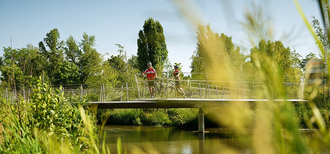 Radler an der Brücke über dem Fischpass im ERBA-Park (Bamberg, Steigerwald)